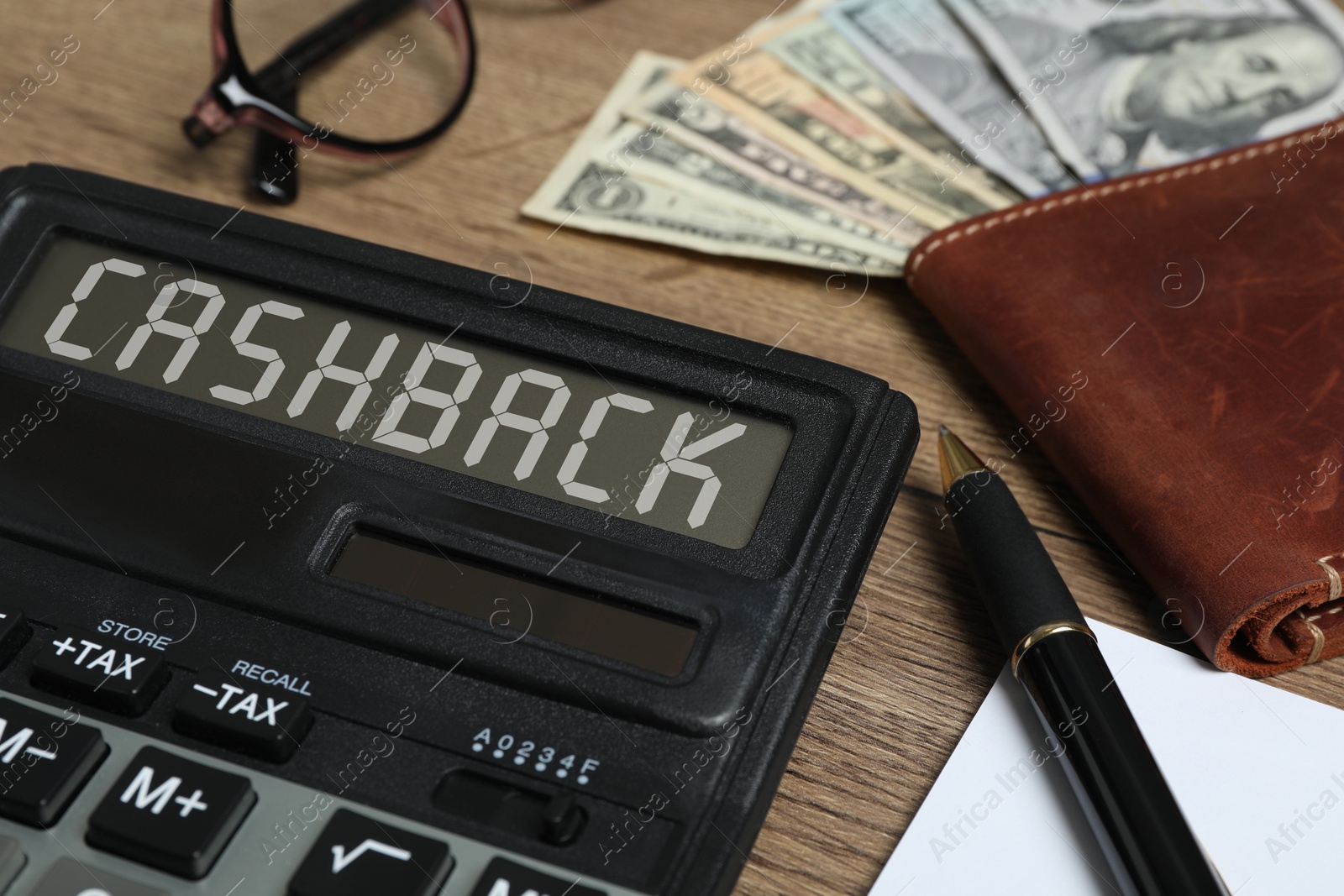 Image of Calculator with word Cashback, pen, wallet and money on wooden table, closeup