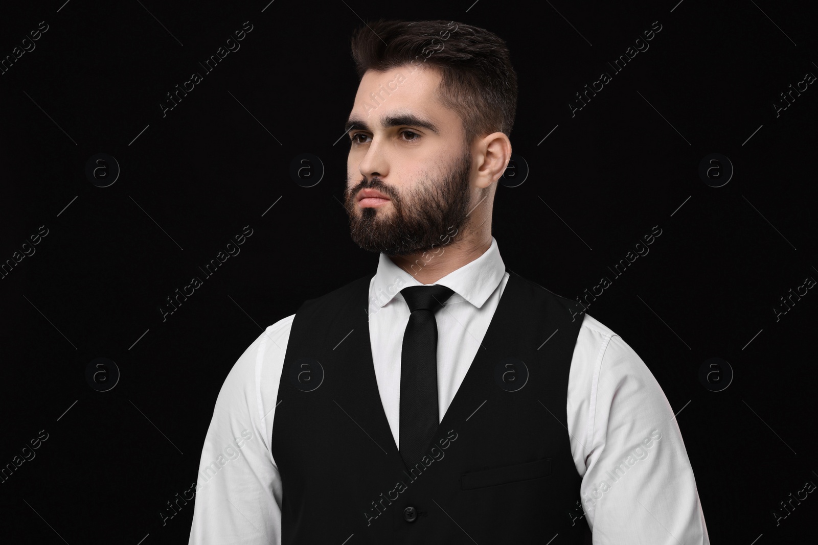 Photo of Handsome businessman in suit and necktie on black background