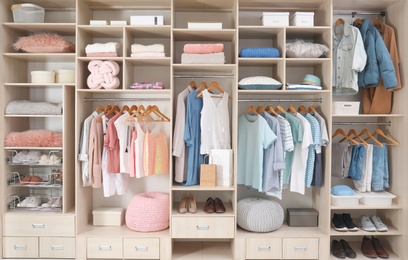 Stylish clothes, shoes and accessories in large wardrobe closet