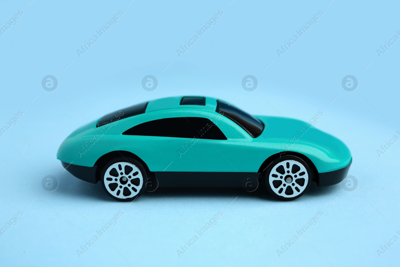 Photo of One bright car on light blue background. Children`s toy