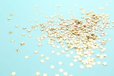 Photo of Confetti stars on light blue background. Christmas celebration