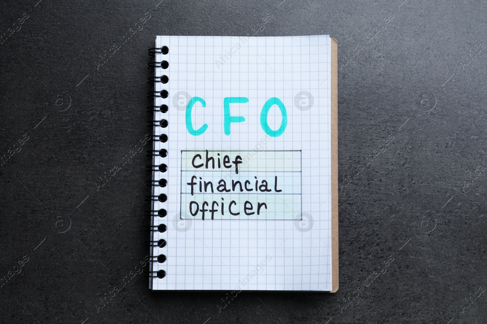 Photo of Notebook with abbreviation CFO (Chief Financial Officer) on grey stone background, top view