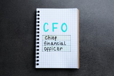 Photo of Notebook with abbreviation CFO (Chief Financial Officer) on grey stone background, top view