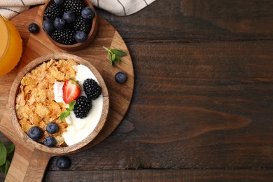 Photo of Delicious crispy cornflakes, yogurt and fresh berries served on wooden table, flat lay with space for text. Healthy breakfast
