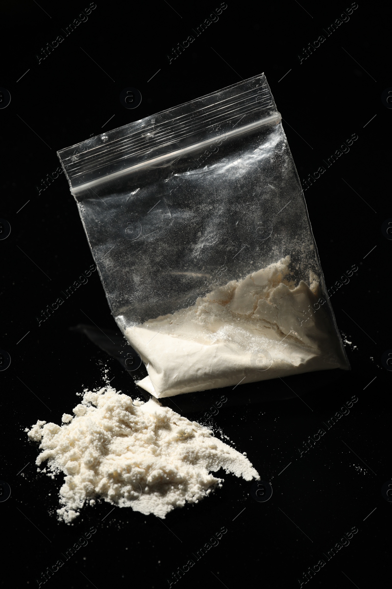 Photo of Drug addiction. Plastic bag with cocaine on black background, closeup