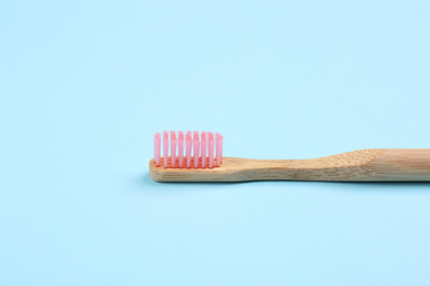 Toothbrush made of bamboo on light blue background