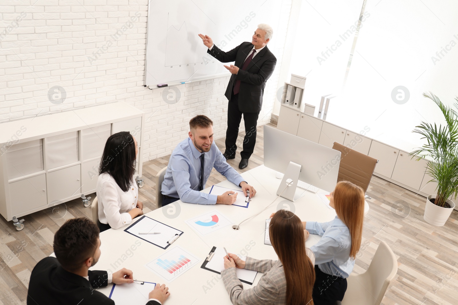 Photo of Senior business trainer working with people in office