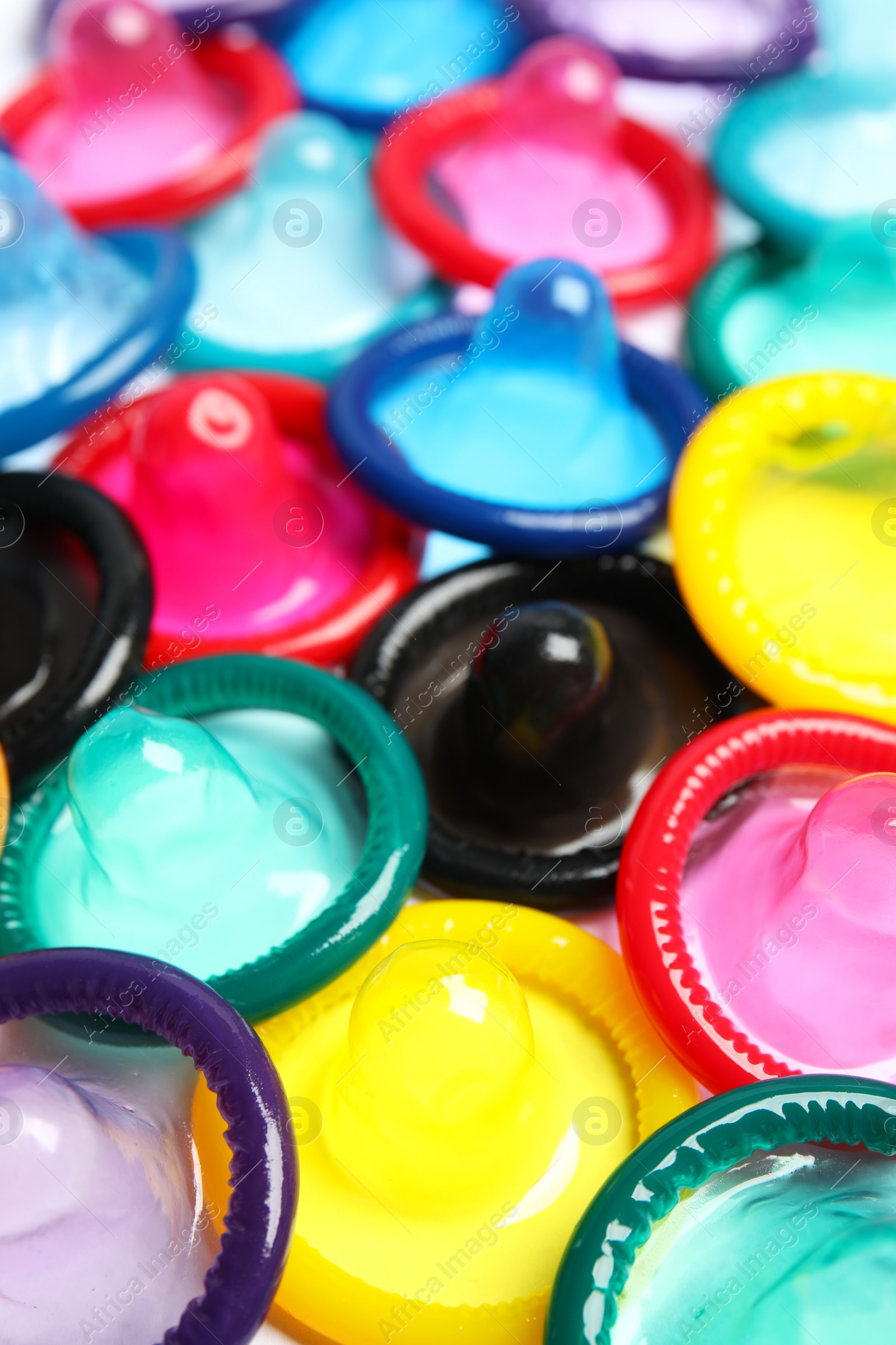 Photo of Unpacked colorful condoms as background, closeup. Safe sex