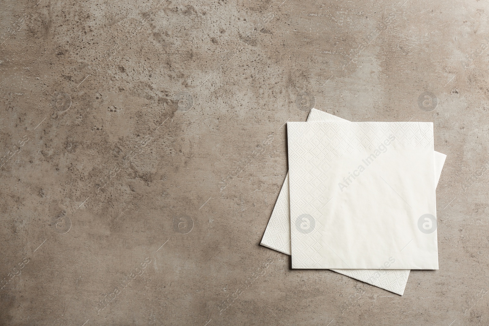 Photo of Clean paper napkins and space for text on grey background, top view