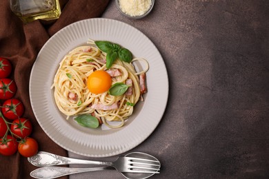 Delicious pasta Carbonara with egg yolk served on grey table, flat lay. Space for text