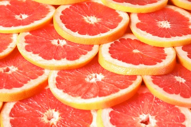 Many sliced fresh ripe grapefruits as background, closeup