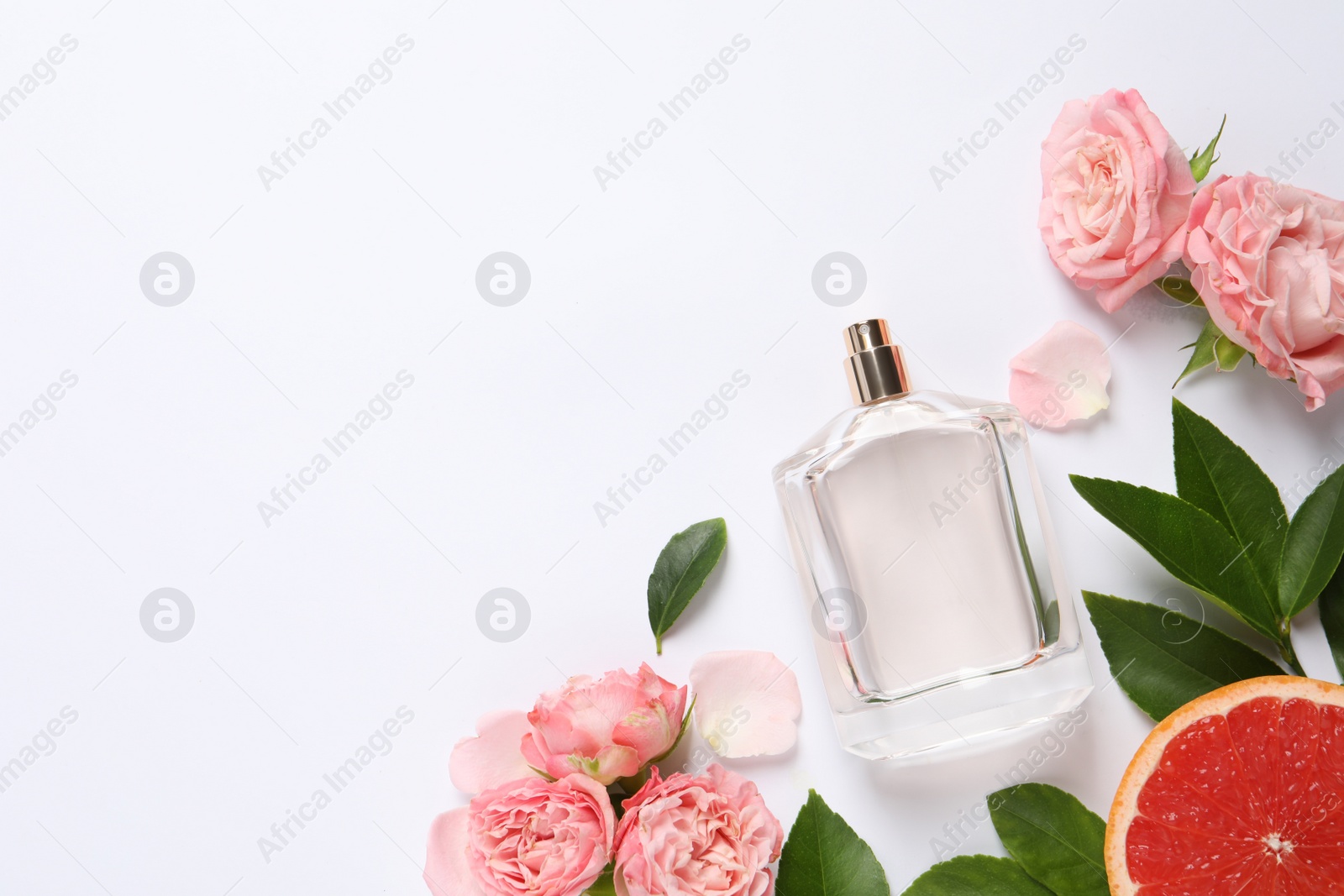 Photo of Composition with bottle of perfume and fresh citrus fruit on white background, top view. Space for text