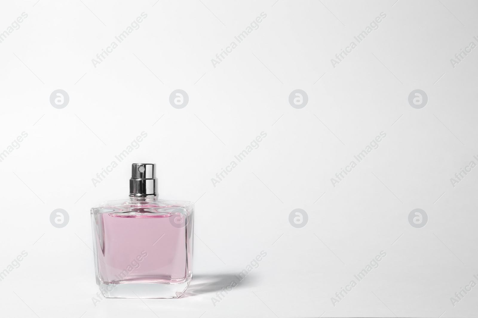 Photo of Bottle of perfume on light background