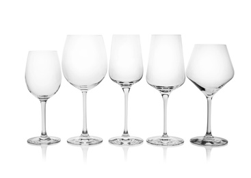 Photo of Different empty wine glasses on white background