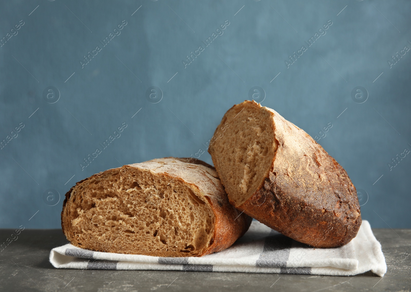 Photo of Cut loaf of bread on table against color background. Space for text