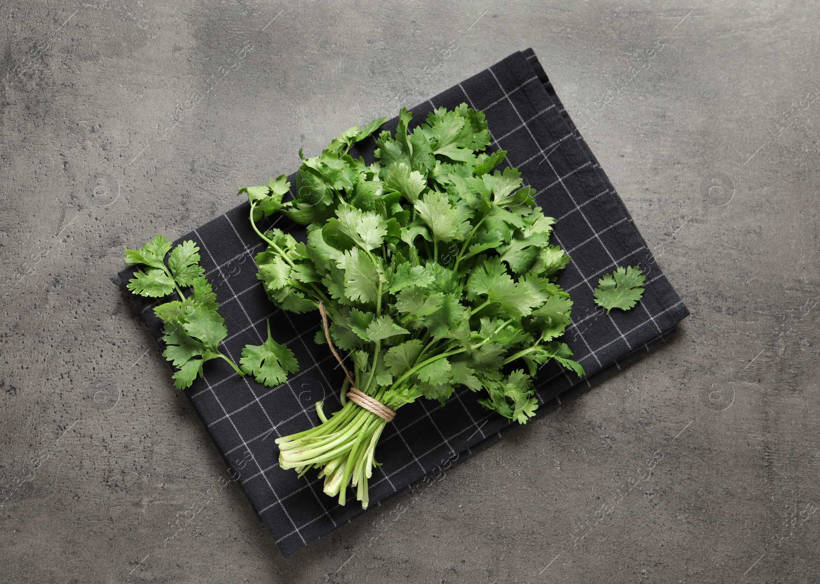Photo of Bunch of fresh aromatic cilantro on grey table, top view
