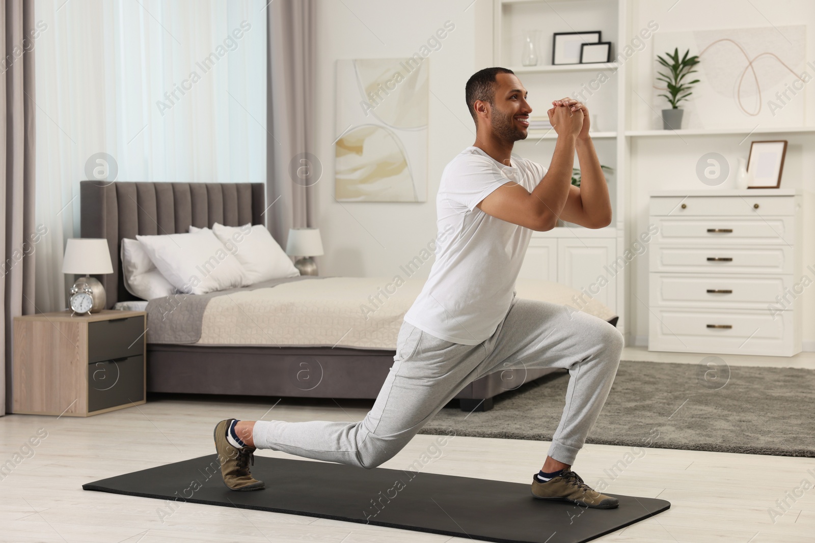 Photo of Man doing morning exercise on fitness mat at home