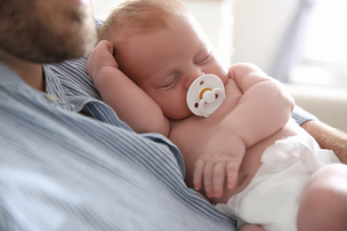 Father with his newborn son at home, closeup