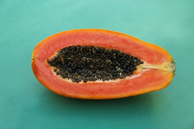 Half of fresh ripe papaya fruit on light blue background