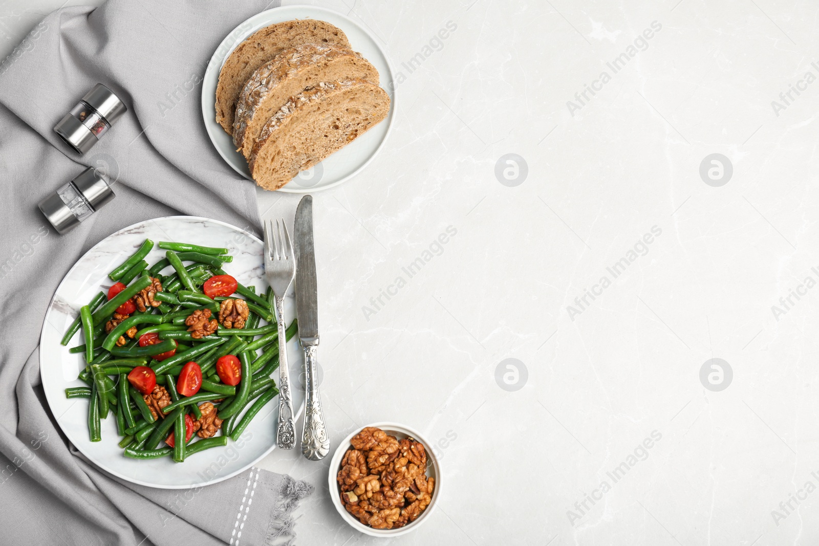 Photo of Tasty green beans with walnuts and tomatoes served for dinner on table, top view