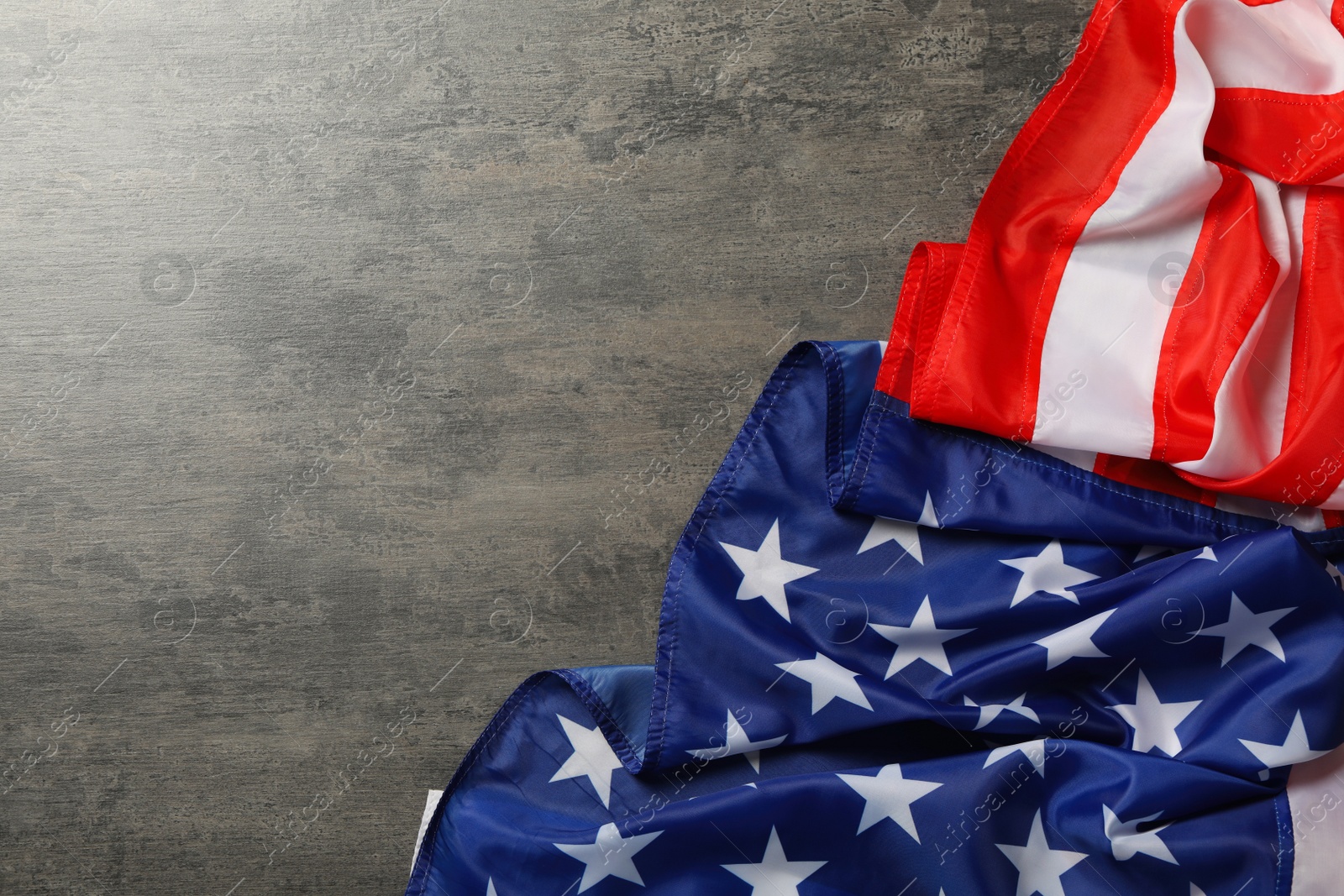 Photo of American flag on grey table, top view with space for text. Memorial Day