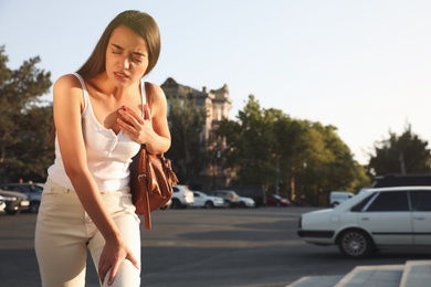 Photo of Young woman having heart attack on city street