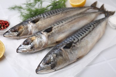 Photo of Tasty salted mackerels on white table, closeup