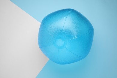 Photo of Light blue beach ball on color background, top view