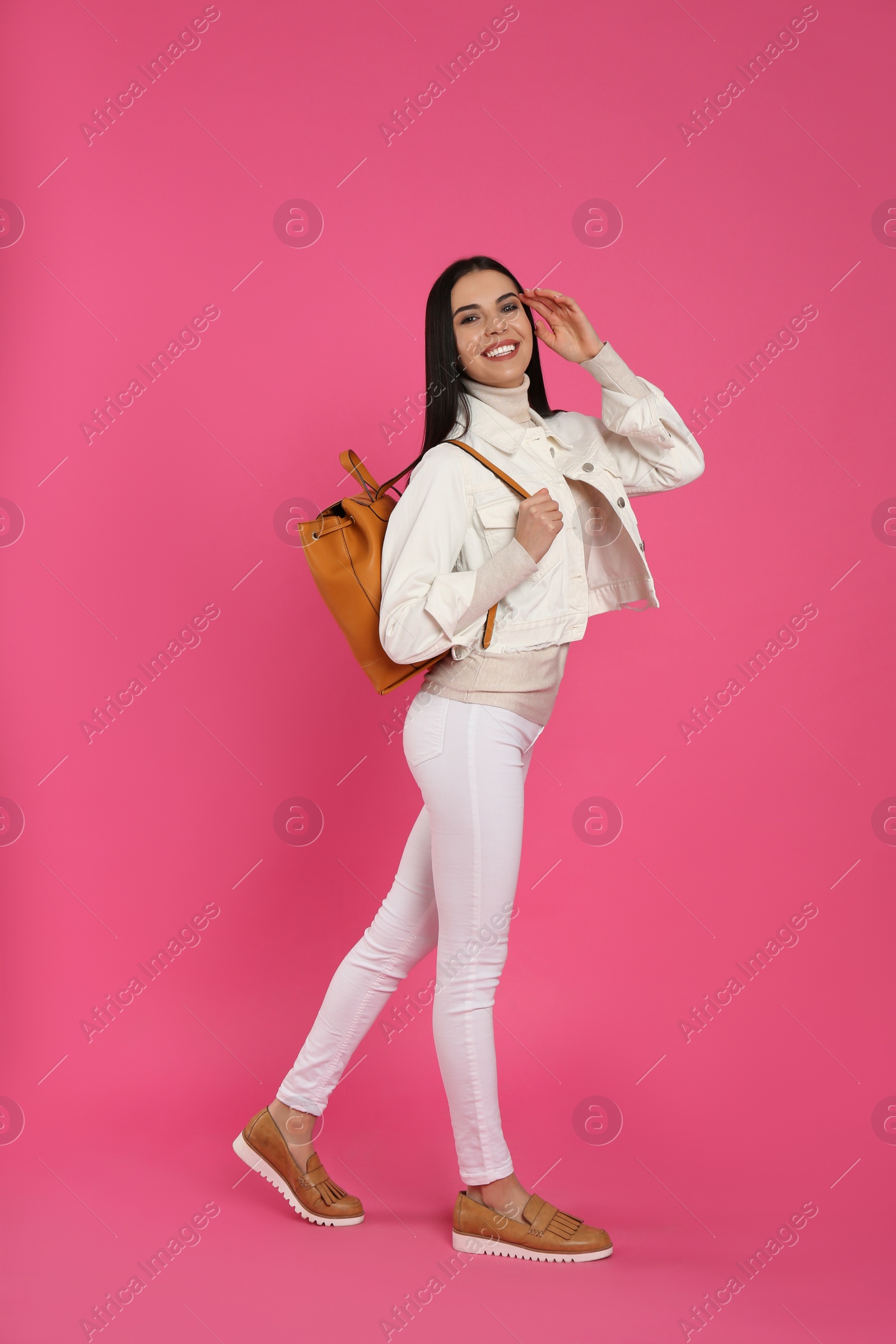 Photo of Young woman with stylish backpack on pink background