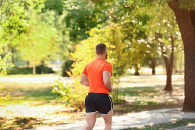 Young man running in park on sunny day