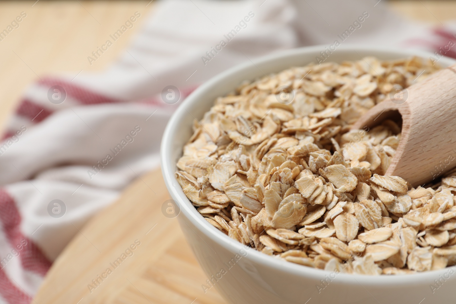 Photo of Bowl and scoop with oatmeal on table, closeup. Space for text