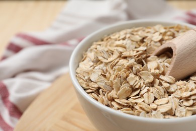 Photo of Bowl and scoop with oatmeal on table, closeup. Space for text