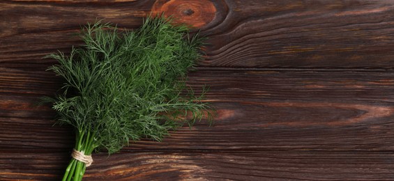 Image of Fresh dill on wooden table, top view. Banner design with space for text