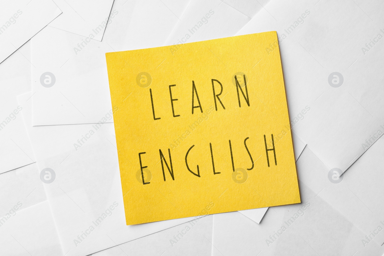 Image of Note with text Learn English on sheets of paper, top view
