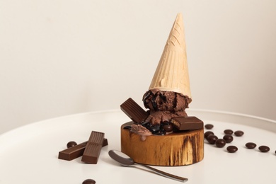 Photo of Delicious ice cream with chocolate in wafer cone served on white table