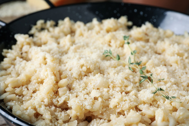Photo of Delicious risotto with cheese in pan, closeup