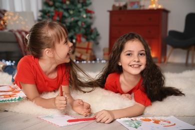 Photo of Little children with drawings and letter to Santa at home. Christmas celebration