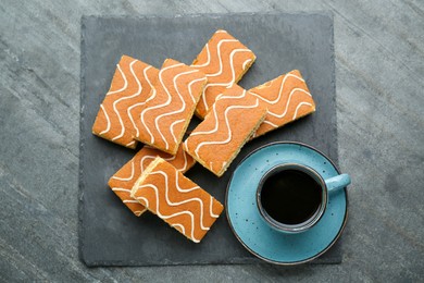 Photo of Tasty sponge cakes and hot drink on grey table, flat lay
