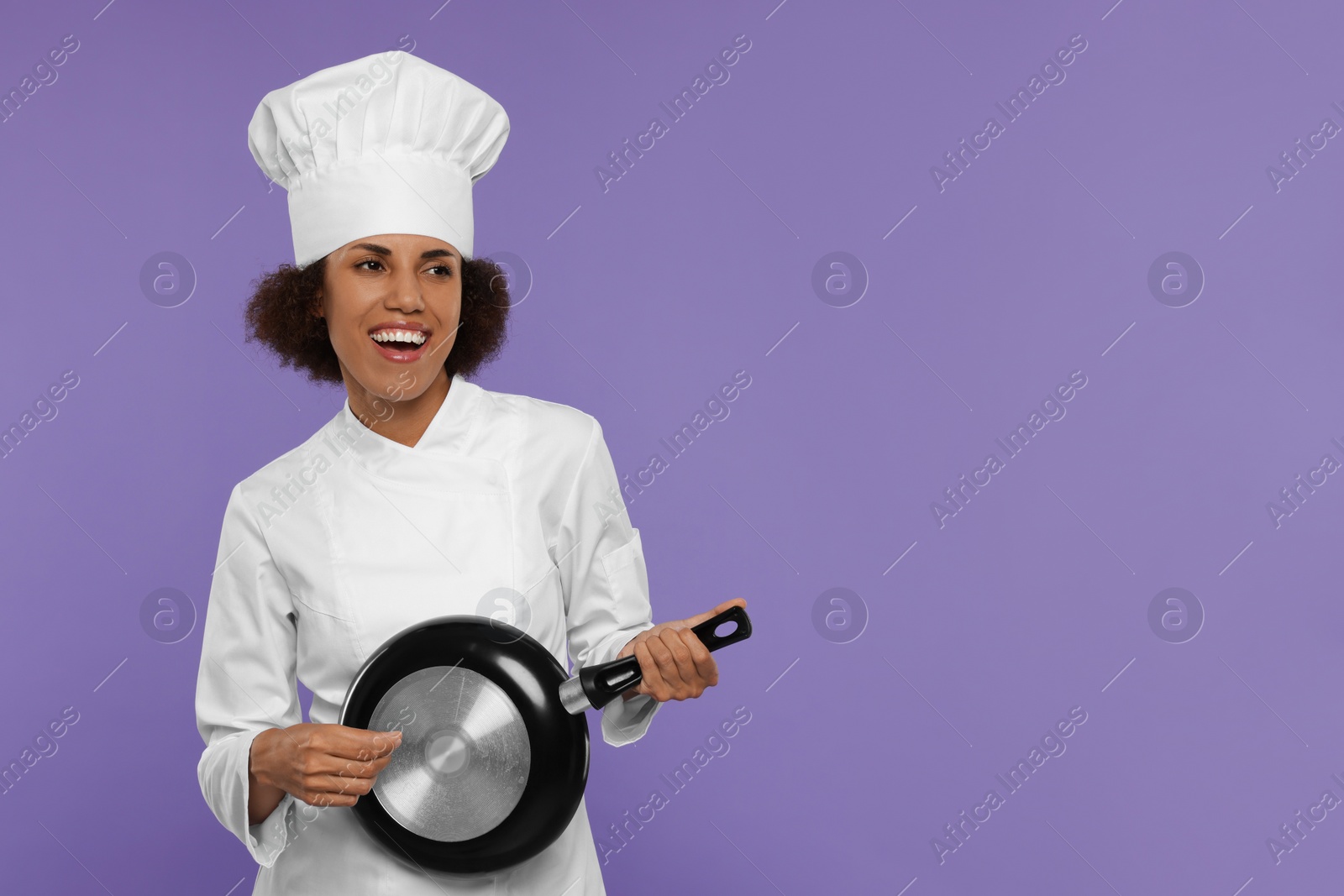 Photo of Happy female chef with frying pan having fun on purple background. Space for text