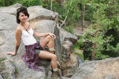 Photo of Young woman on rocky mountain in forest. Camping season