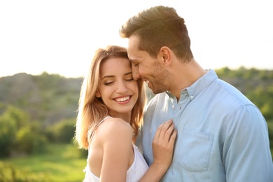 Cute young couple in love posing outdoors on sunny day