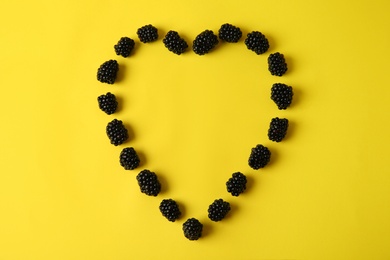 Photo of Flat lay composition with ripe blackberries on yellow background. Space for text