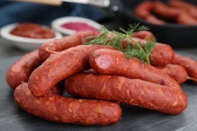 Photo of Delicious sausages and dill on grey table, closeup