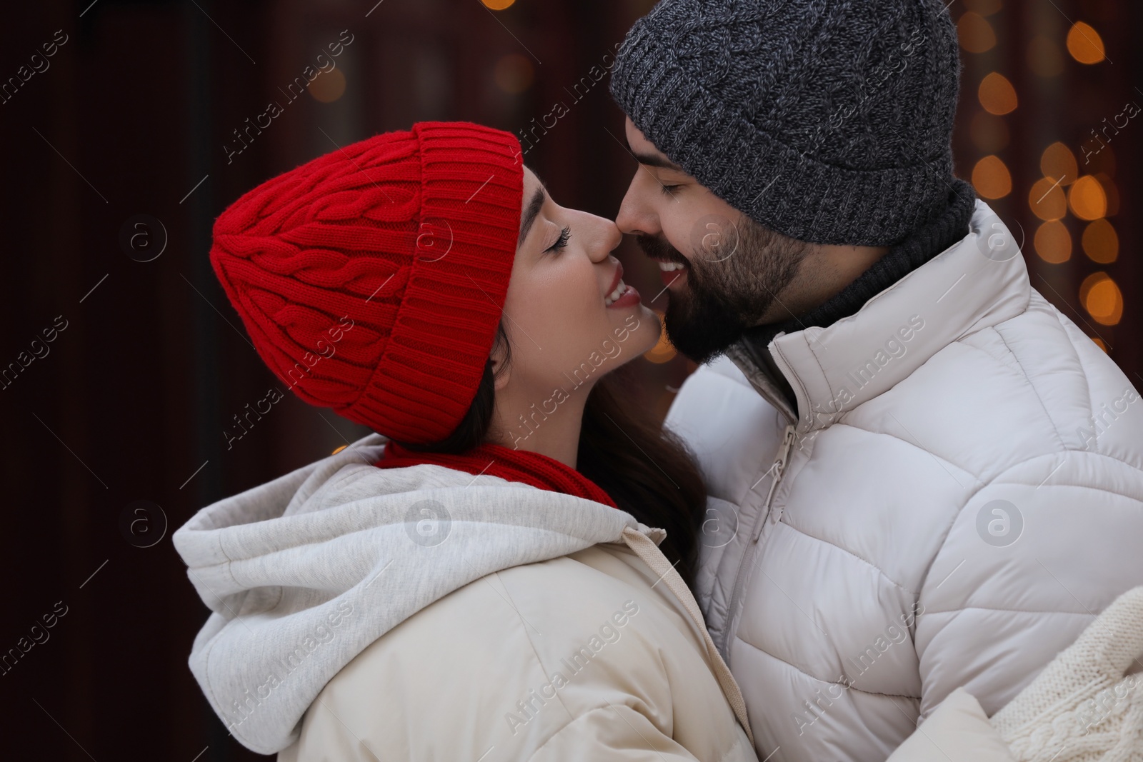 Photo of Portrait of lovely couple outdoors against blurred lights outdoors