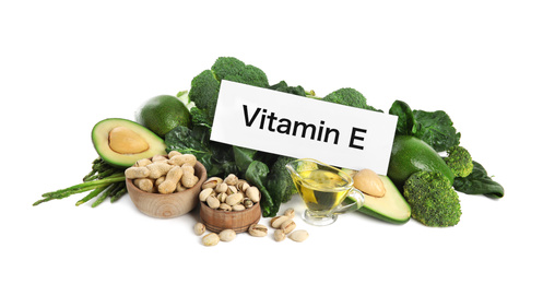 Photo of Card with phrase Vitamin E and different products on white background