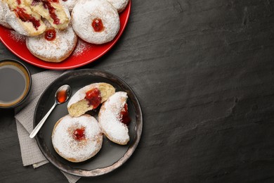 Photo of Delicious jelly donuts served with coffee on black table, flat lay. Space for text