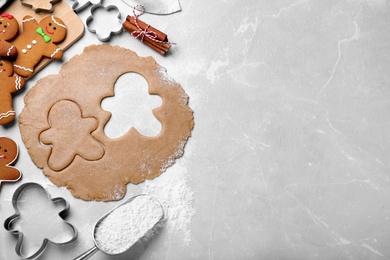 Flat lay composition with homemade gingerbread man cookies on light grey table, space for text