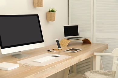 Stylish workplace interior with modern computer on table. Mockup for design