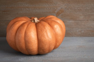 Photo of Fresh ripe pumpkin on grey wooden table