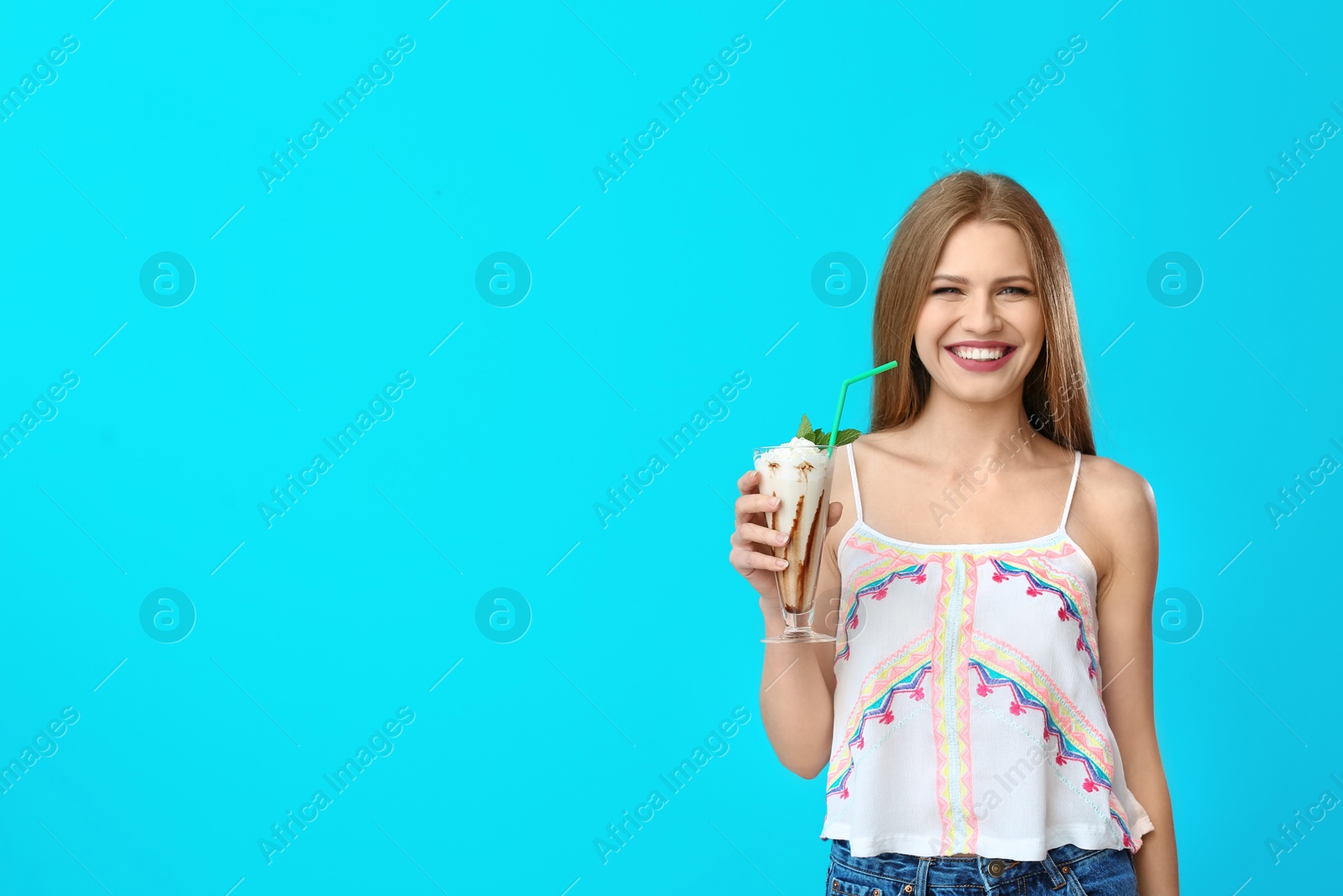 Photo of Young woman with glass of delicious milk shake on color background